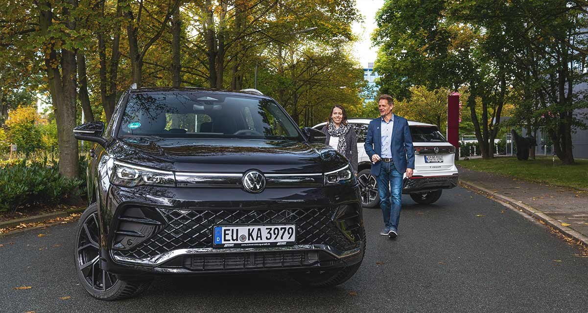 Ein moderner VW Tiguan der Arndt Autovermietung vor herbstlicher Kulisse. Zufriedene Kunden auf dem Weg zum Auto zu ihrem Werkstatt-Ersatzwagen | Autovermietung Arndt für Firmenkunden