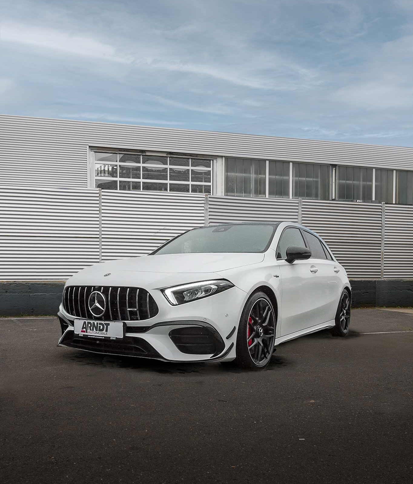 Weißer Mercedes-AMG A 45 S Mietwagen bei Autovermietung Arndt, High-Performance Kompaktsportler mit Panamericana-Grill und roten Bremssätteln