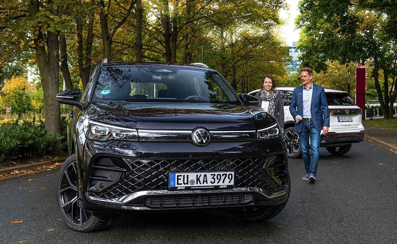 Ein moderner VW Tiguan der Arndt Autovermietung vor herbstlicher Kulisse. Zufriedene Kunden auf dem Weg zum Auto für die nächste Geschäftsreise.| Autovermietung Arndt für Firmenkunden