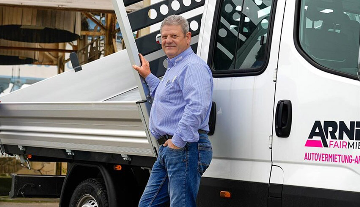 Professionelle Transportlösungen: Ein Mitarbeiter präsentiert einen modernen Pritschenwagen | Autovermietung Arndt für Firmenkunden